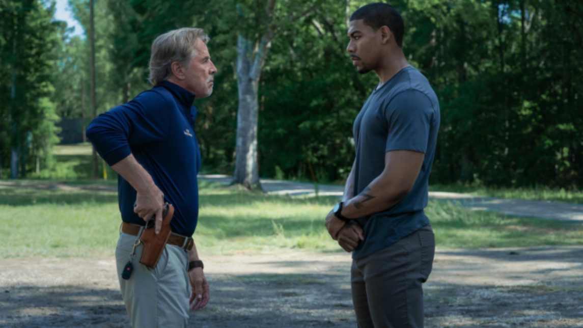 Aaron Pierre & Don Johnson Showdown in the movie Rebel Ridge, in a opside clearing, trees in the background