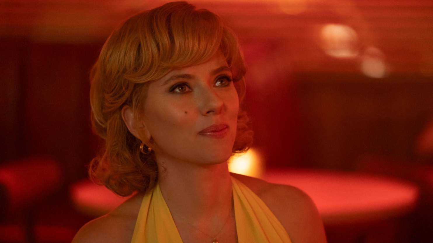 Scarlett Johansson as Kelly Jones in Fly Me to the Moon, wearing a yellow dress, in a diner, looking up in awe