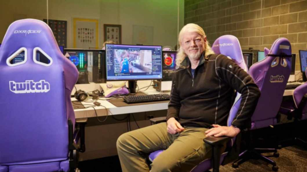 Dan Clancy, CEO of Twitch, sat in a purple DXR Racer gaming chair, in a small office, posing for camera