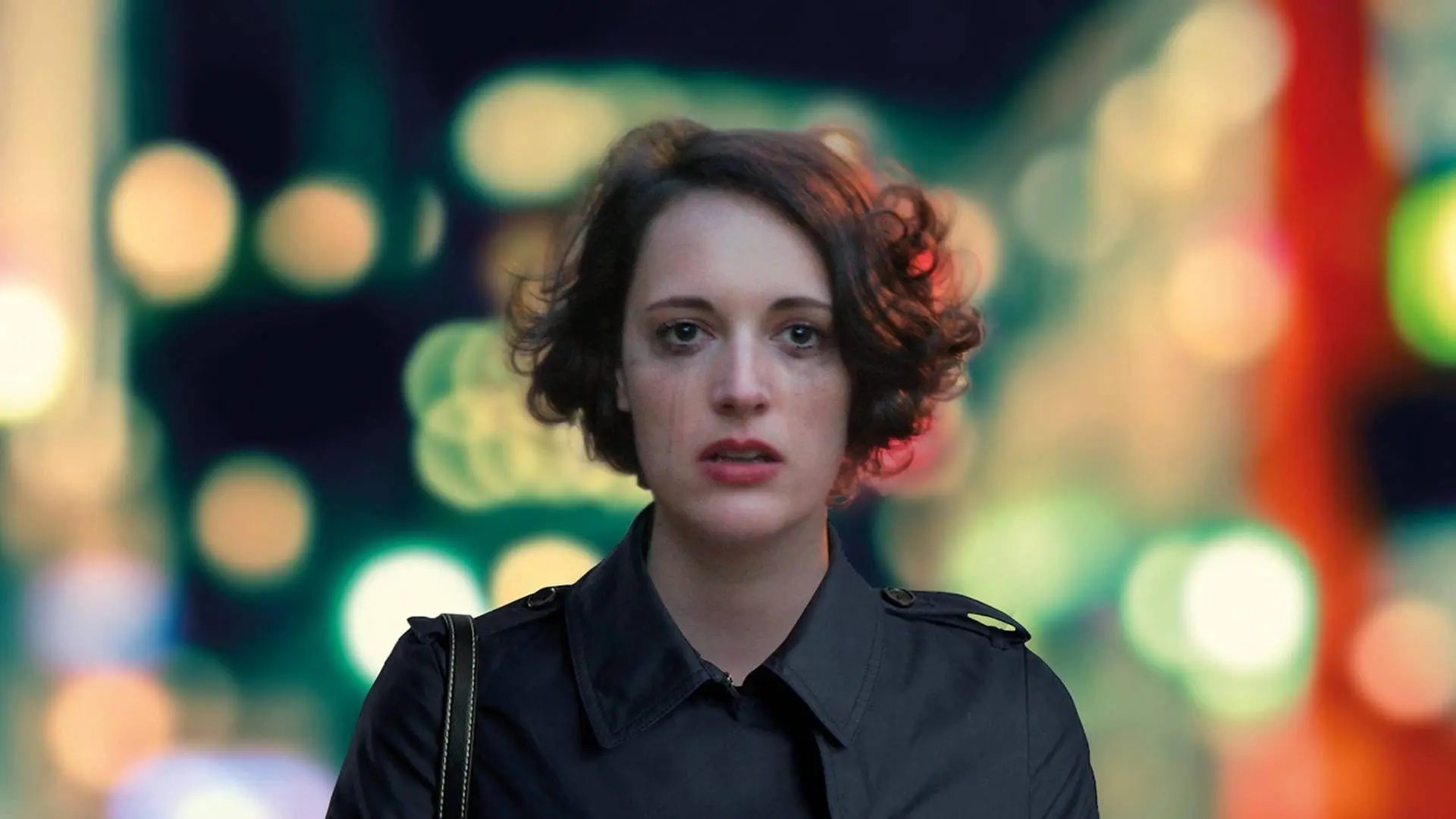 Fleabag, played by Phoebe Waller-Bridge, looks tearfully at the camera with smudged mascara, against a blurry city nightscape.